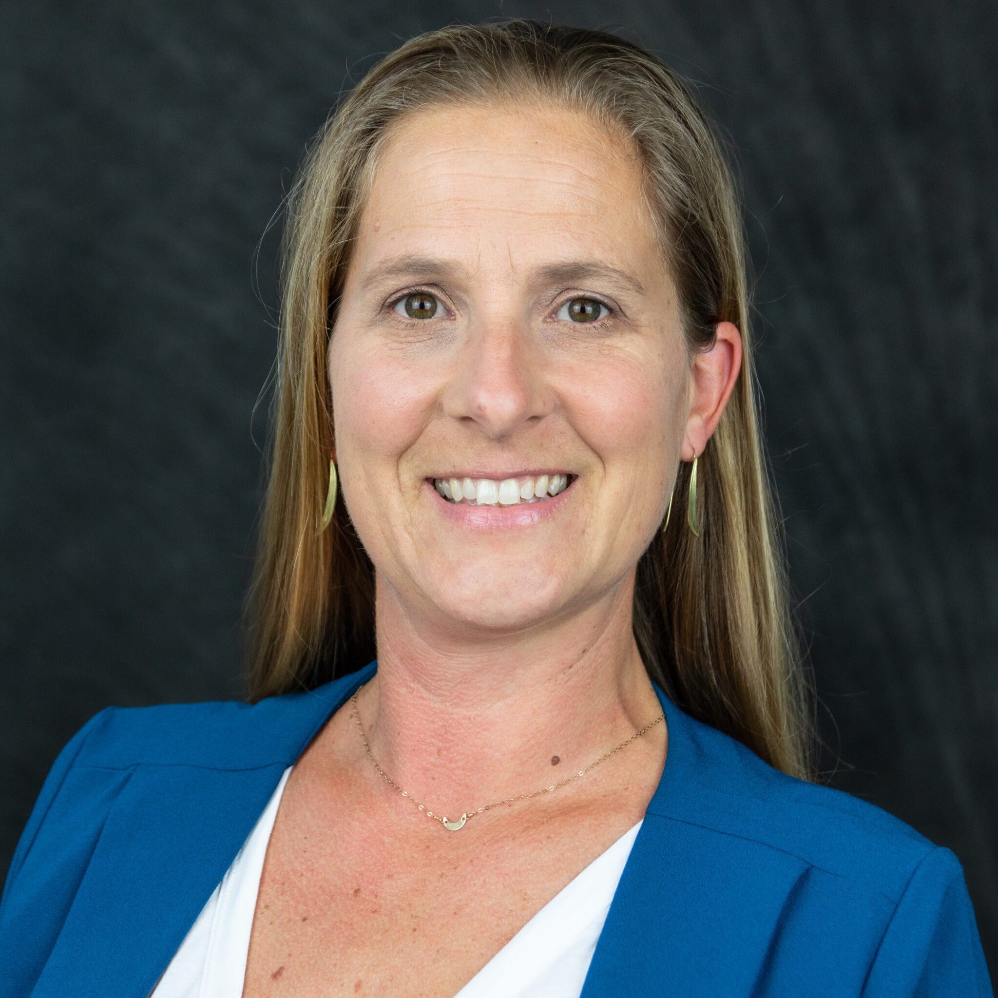 Headshot of Koty Sharp, woman in blue suit jacket and long blonde hair.