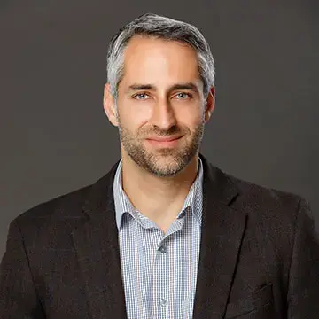 Sargon Donabed, portrait of a man with a blue collared shirt and black jacket.