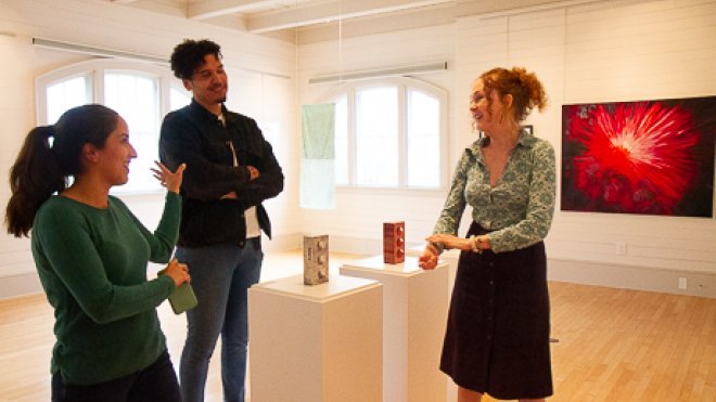 People discussing art in exhibit.