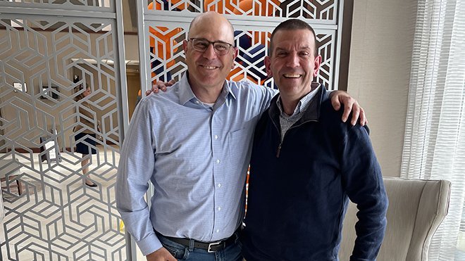 Dean Griffin stands with his college roommate