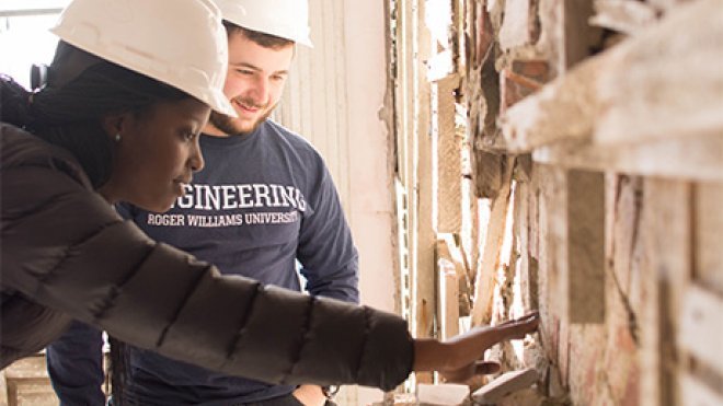 Engineering students examining a deteriorated wall.