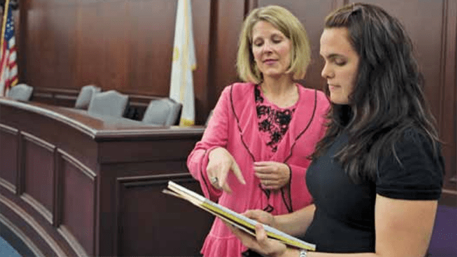 Tricia Martland assists a student in the courtroom