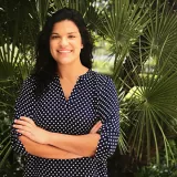 Morgan Branco stands in front of palm leaves