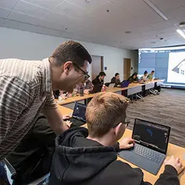 Professor assists student with computer