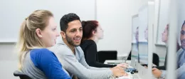 students work on computers and smile