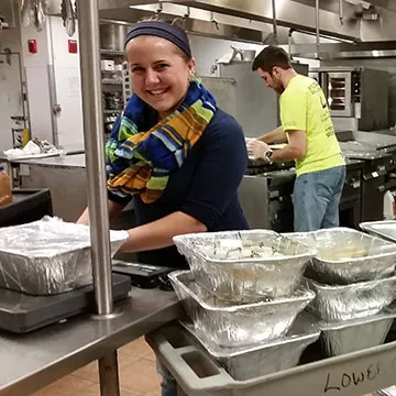 A headshot Kelsey Rogers working in the RWU kitchen