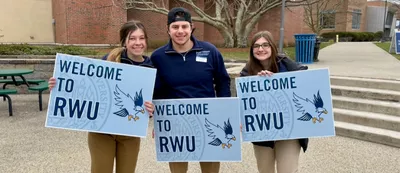 Students with signs saying welcome to rwu
