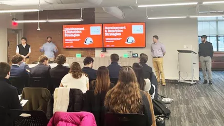 MBA students present their final recommendations to Shawmut Design and Construction executives at the company's Providence office.