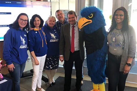 President Miaoulis poses with RWU's mascot and employees.