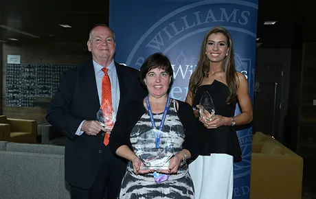 Three alumni hold their awards.