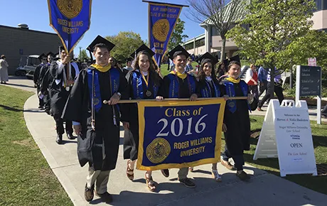 The Class of 2016 processes to commencement holding the class banner.
