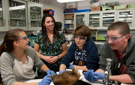 Student discusses a project with professors.