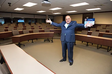 Professor Santoro stands inside the classroom dedicated to him.