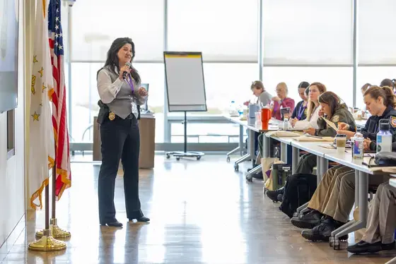 Woman with microphone speaking to classroom of students
