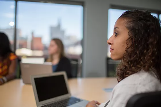 A woman in a class looks at the professor.