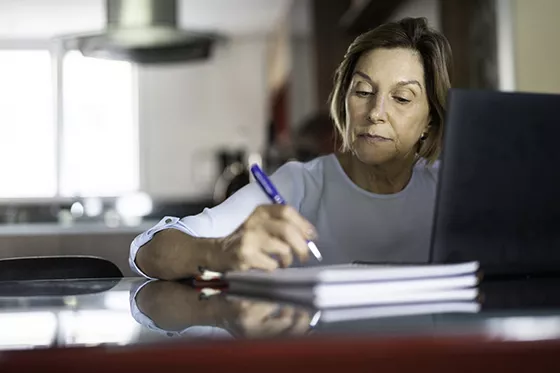 Person taking notes at computer