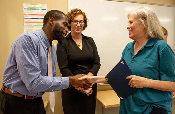 A handshake offered in congratulations after a participant completes a program at University College