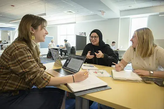 Three students study together in the library