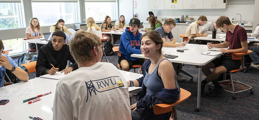 An RWU classroom with students talking and working together