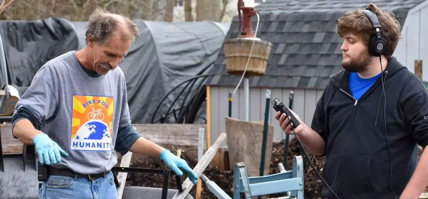 Man doing work with compost being interviewed by Communities of Hope member
