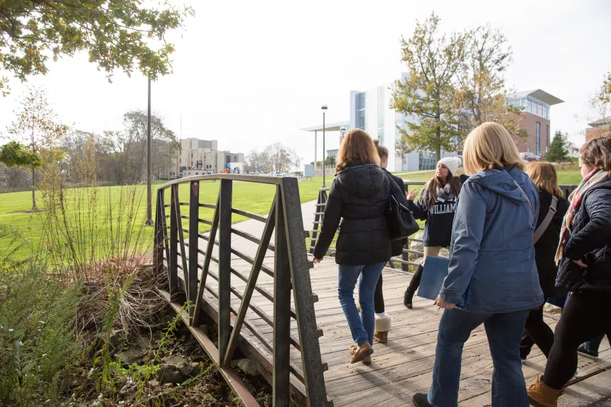 Student leading tour over small bridge