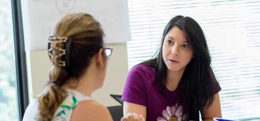 A faculty member talks with a student.