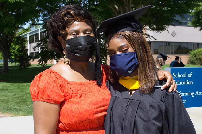 Image of a 2020 graduate posing with a family member