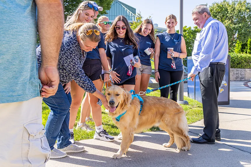Members of the Class of 2028 speak with President Miaoulis as they pet the First Dog, Roger.