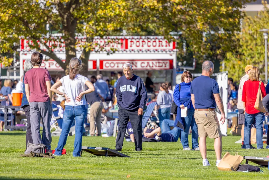 Autumn Festival attendees play games such as cornhole while indulging in tasty treats.