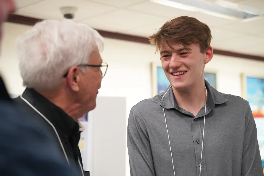 Attendees at RWU's inaugural Blue@RWU Symposium engage with student researchers.