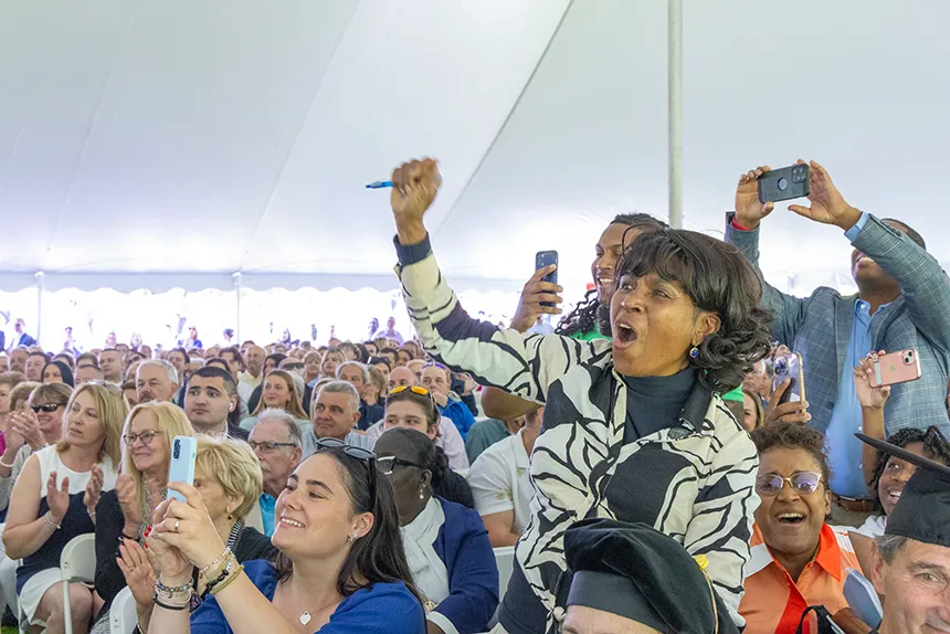 An audience member cheers for the graduates