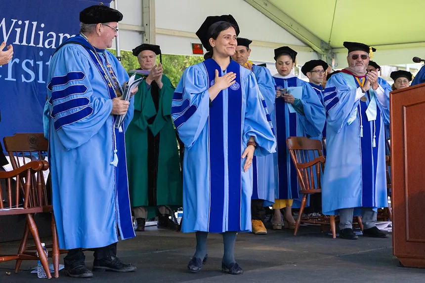 Speakers and faculty stand on stage