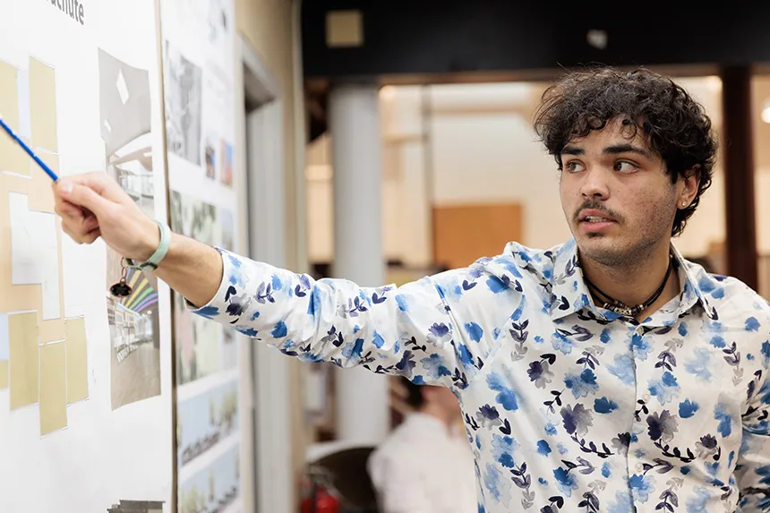An Architecture major points to a poster design 