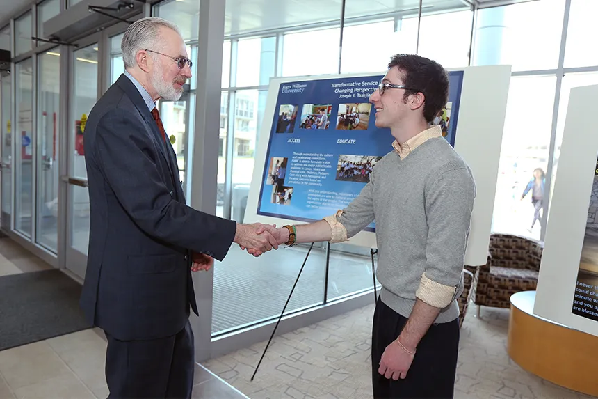 A student shares his research project with President Farish at the annual Student Academic Showcase and Honors celebration.
