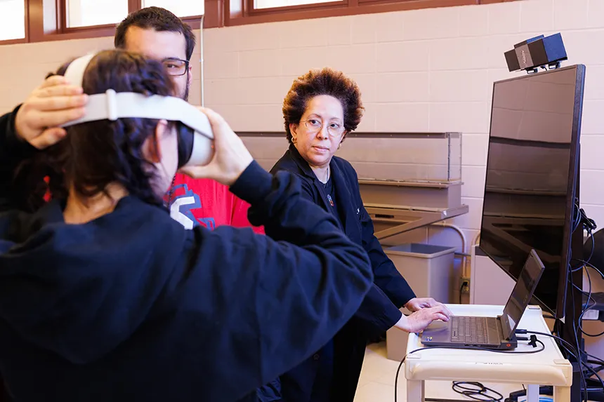 A student puts on a virtual reality headset. 