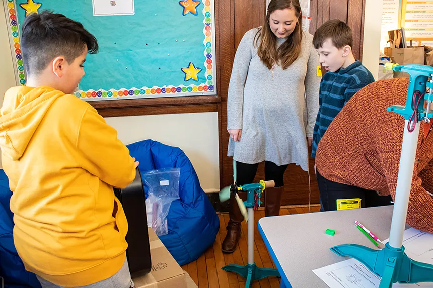 student tests out wind turbine with classroom fan