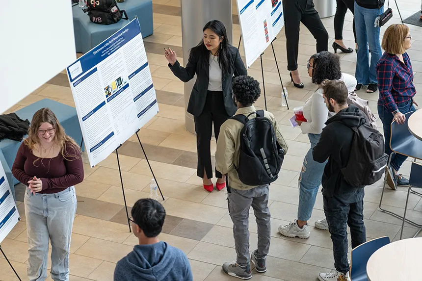A student presenting her poster at SASH. 