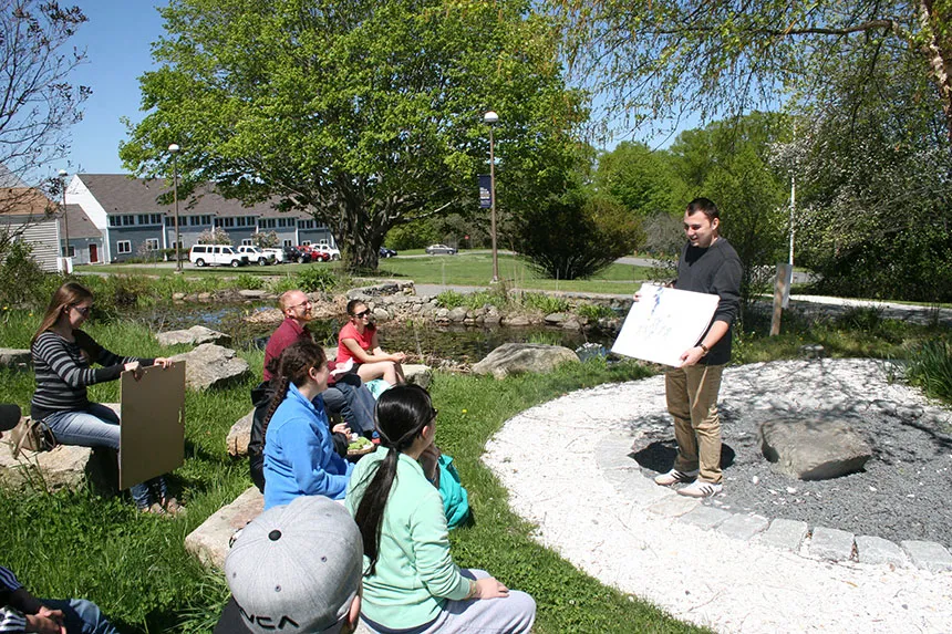 A student shares his work with classmates for a critique.