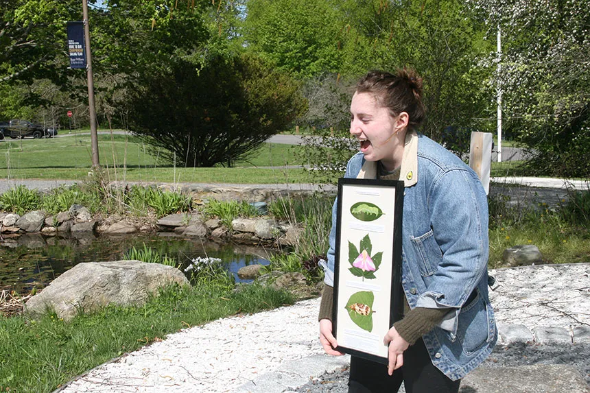 Student displays her plant life cycle illustration.