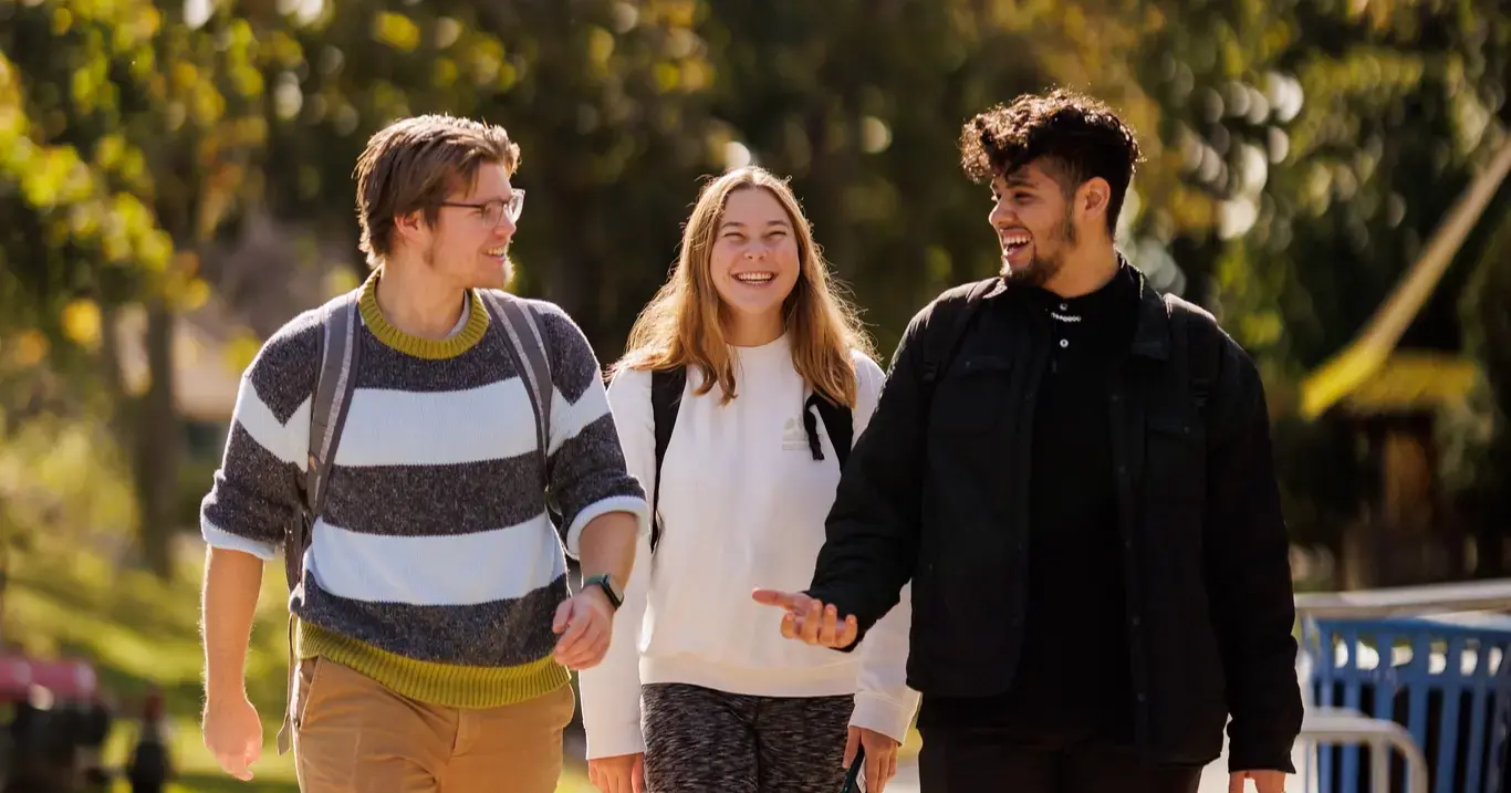 Three students walking on campus