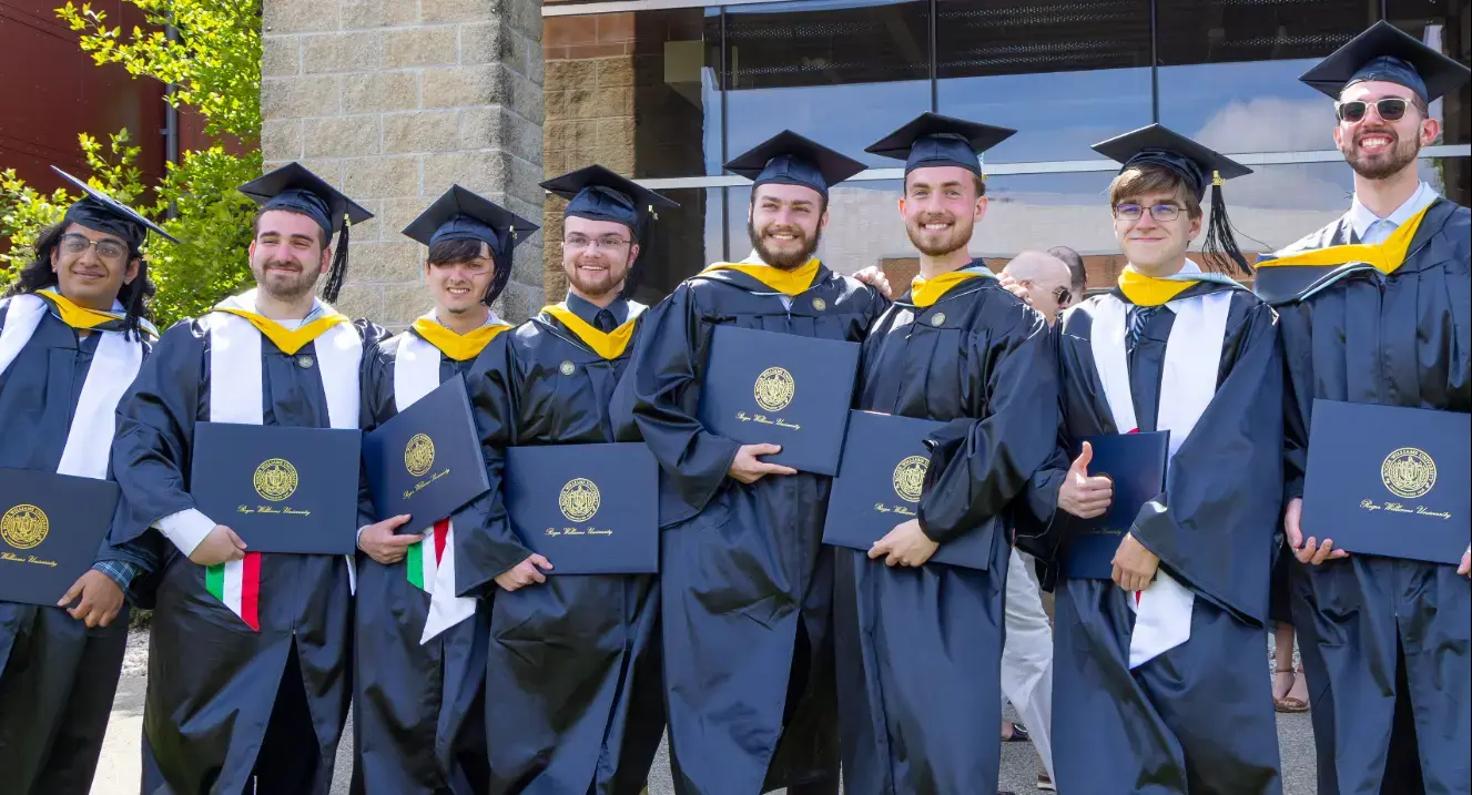 Students posing with degrees at graduation