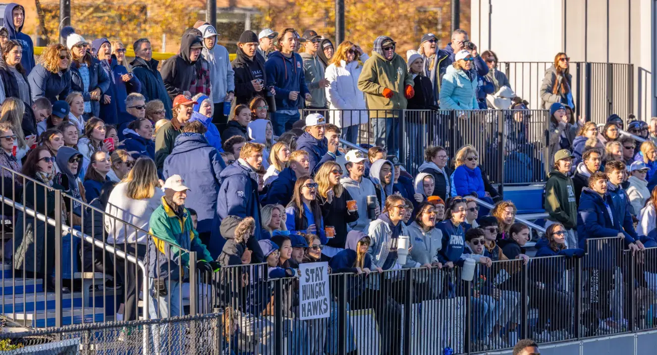 Students cheering on bleachers at sporting event