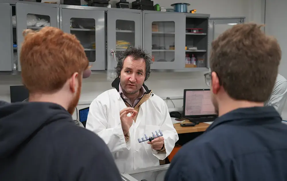 Professor advises students in lab