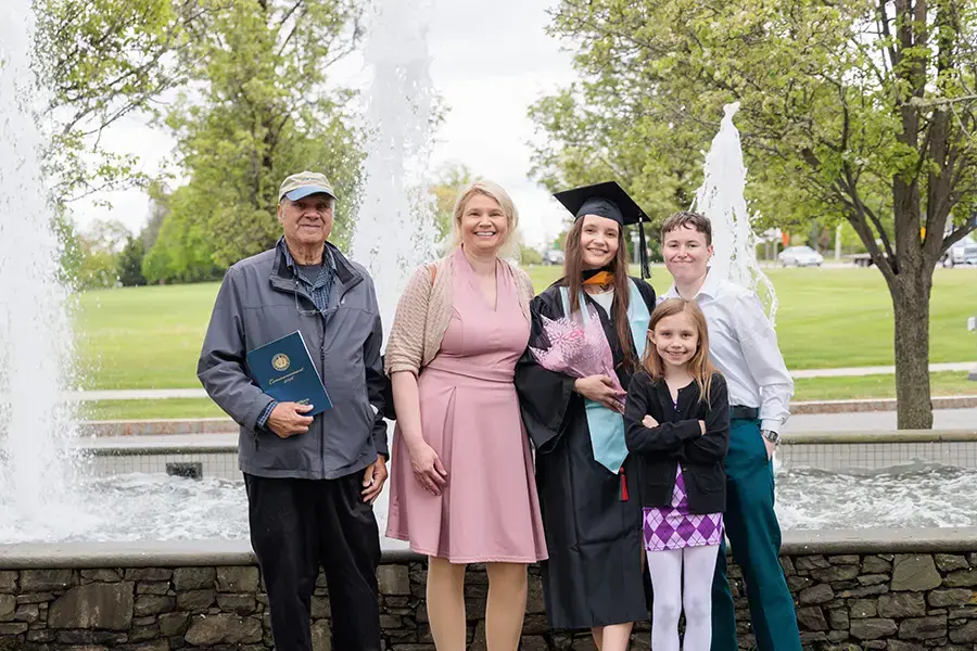 Family poses with graduate at commencement