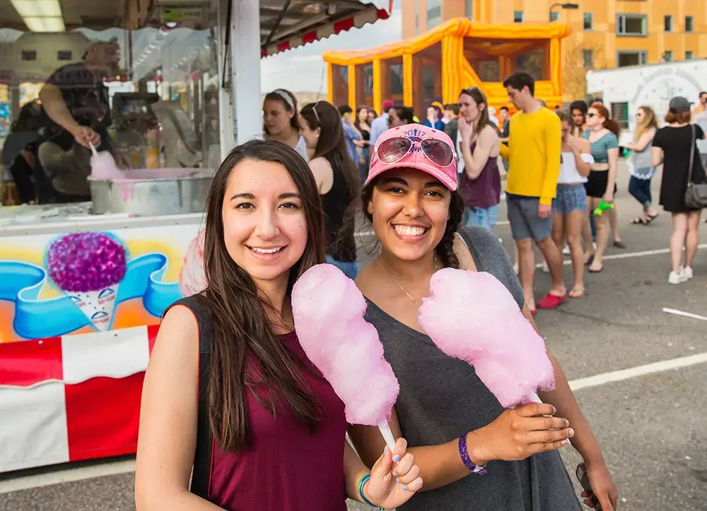 Students eat cotton candy at an on-campus carnival
