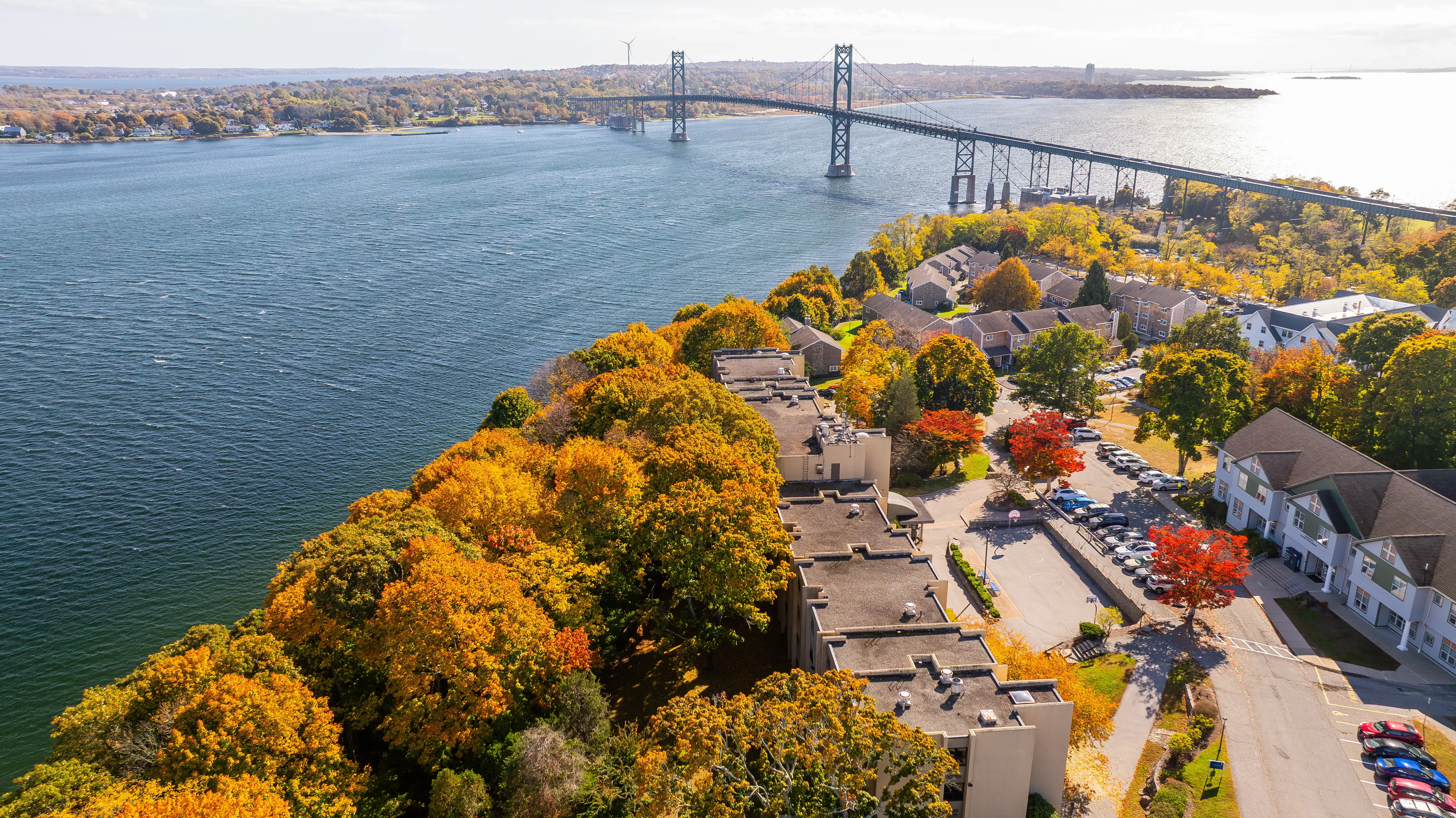 Aerial view of Roger Williams University’s Bristol campus on Narragansett Bay, with the Mount Hope Bridge visible