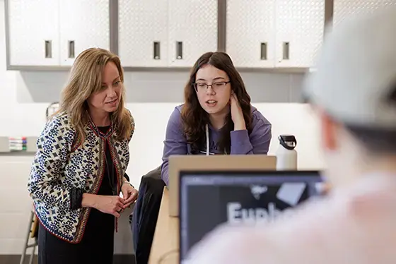A faculty member and a student are looking at a computer together