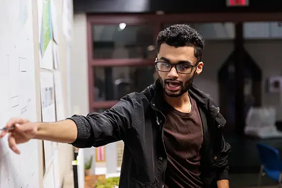 A person points at a poster on the wall